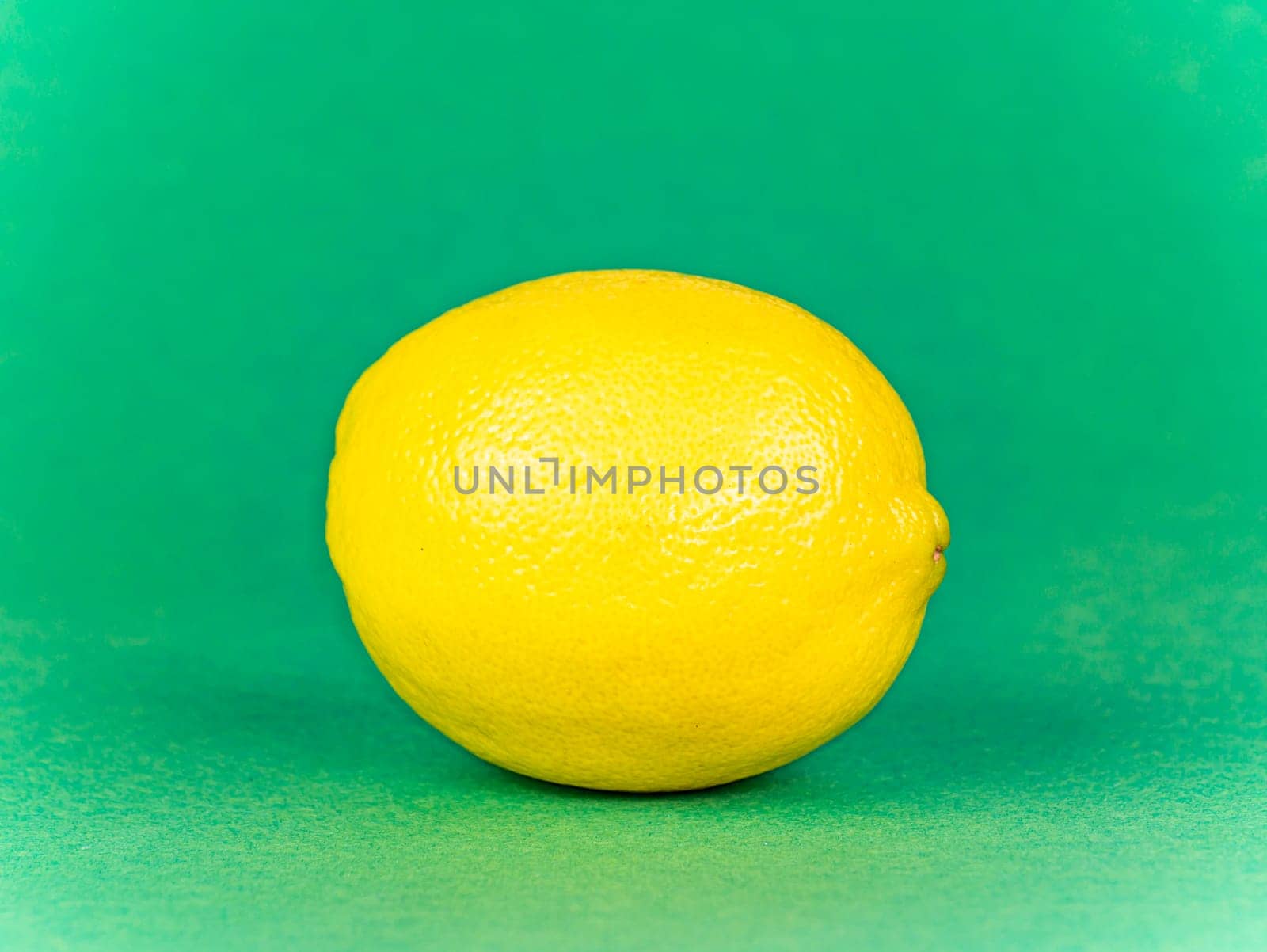 Yellow lemon on a green background. Fruit. Food photo. Place for text. Showcase.