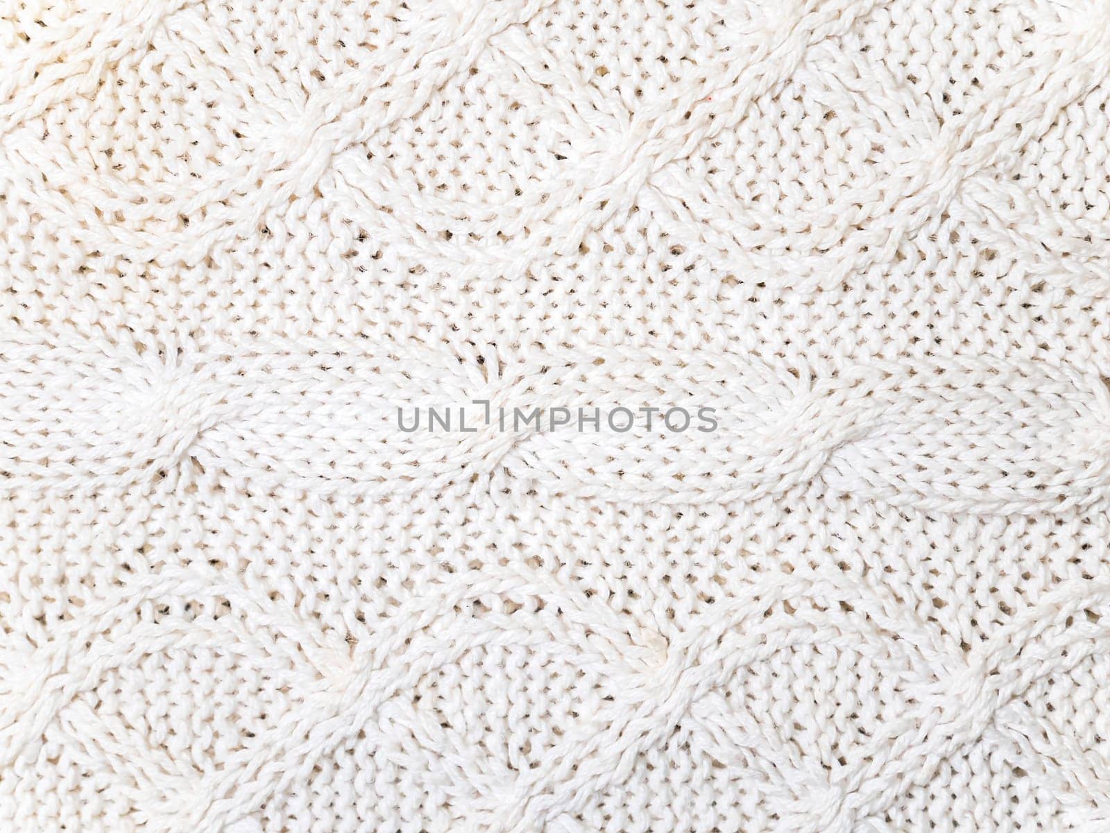 Texture of white woolen knitted fabric. Place for text. Background image.