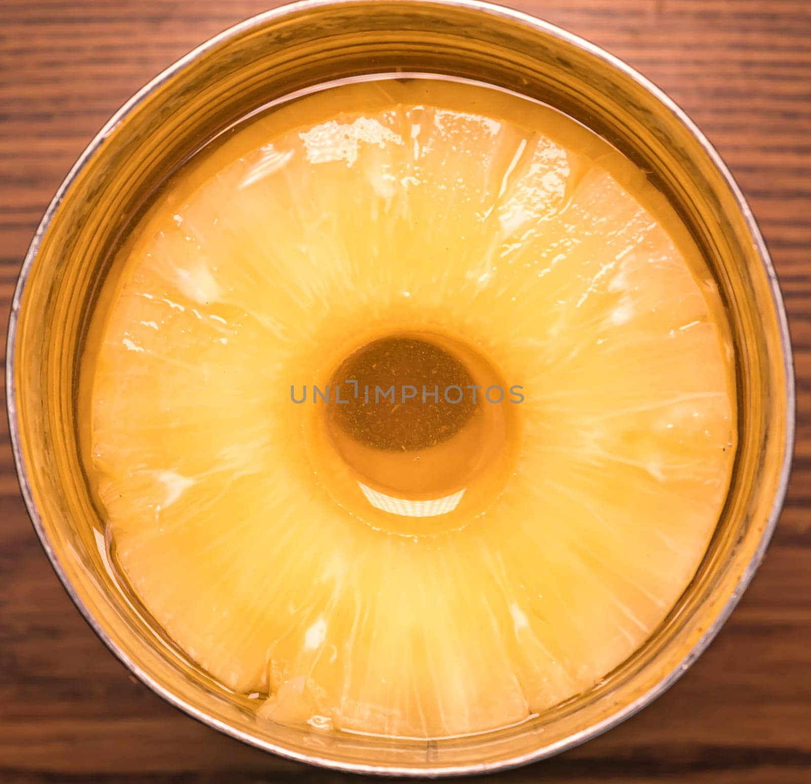 Sliced pineapple in a tin can with juice. Food photo. Place for text.