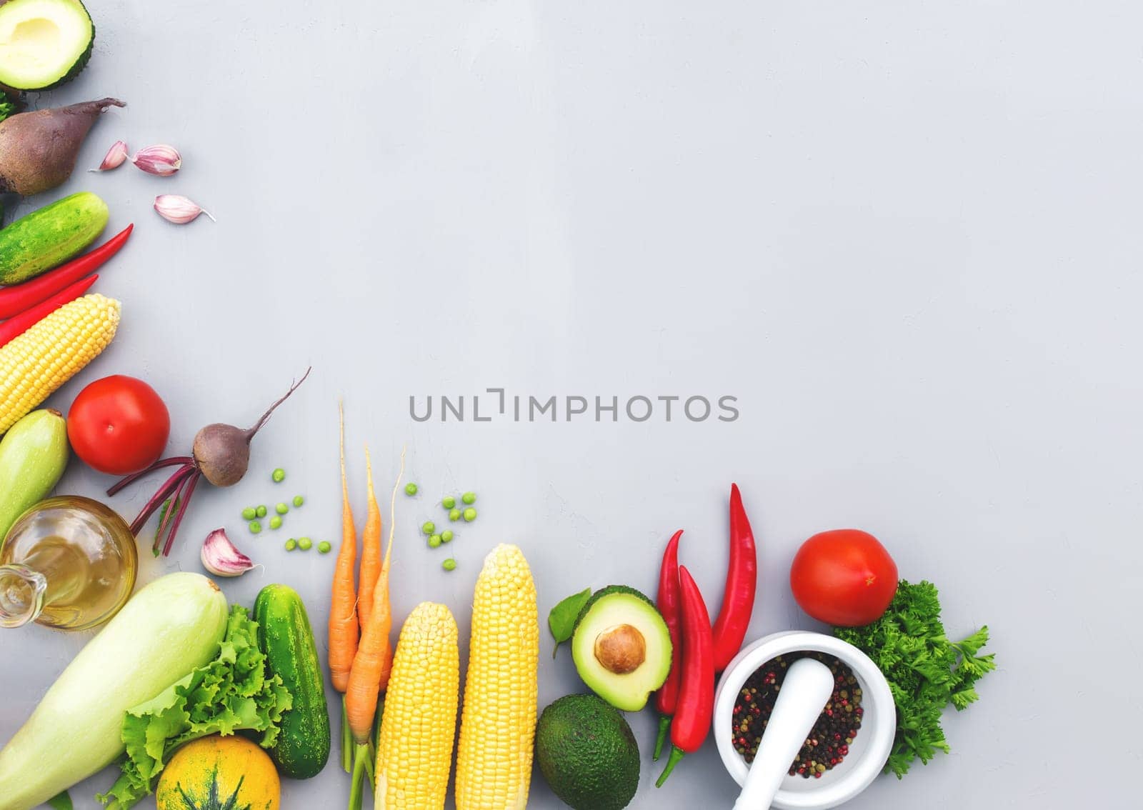 Flat lay with different vegetables, fruits, berries, nuts, spices, herbs, olive oil. Copy space area for some text. Veggies on grey concrete background. Concept of organic bio food healthy eating