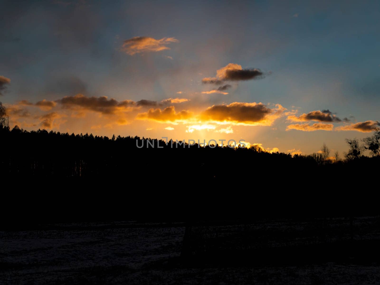 Sunset in the clouds over the forest horizon. Nature. Scenery. Background image.