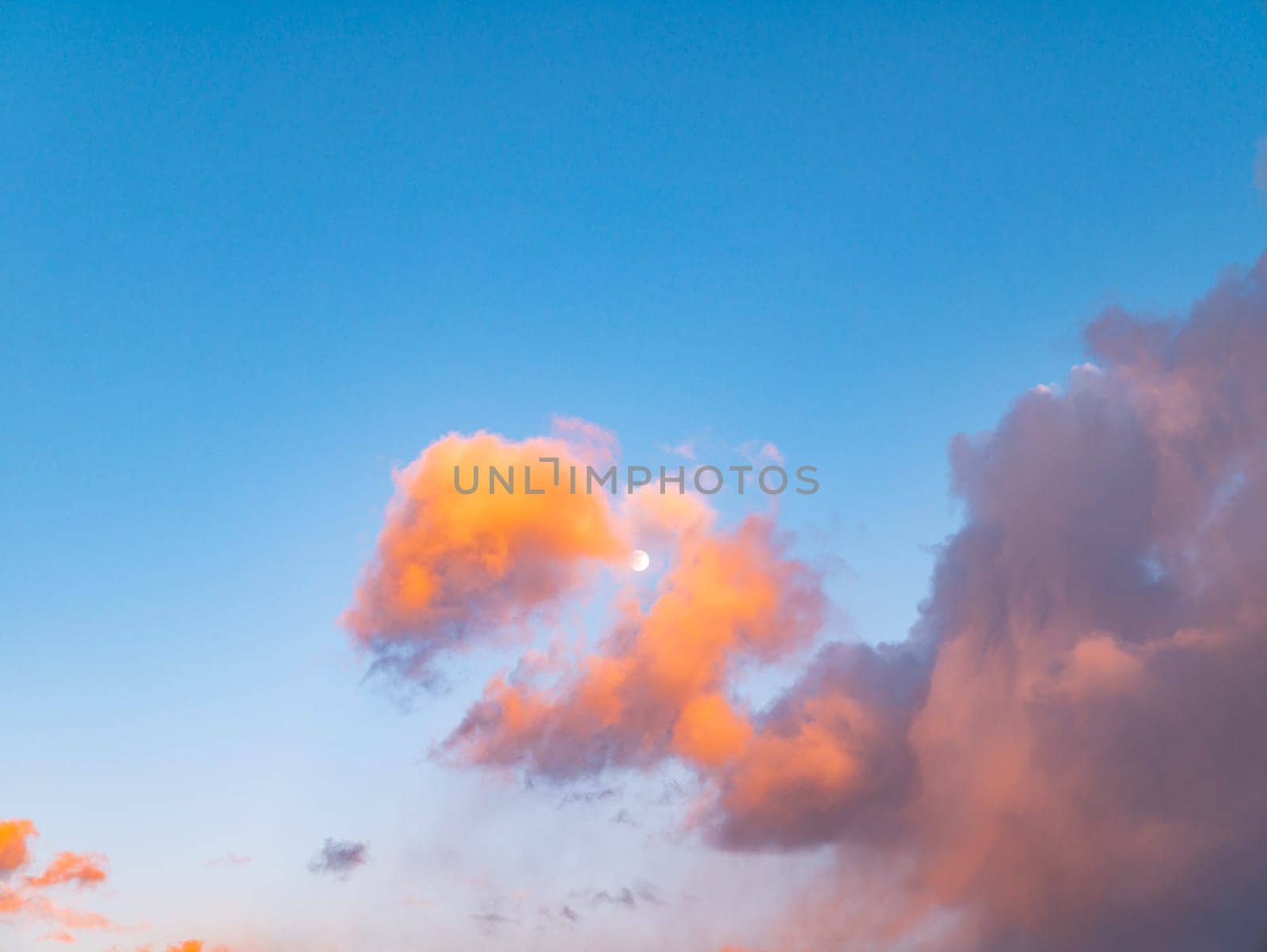 Cloudy landscape with the moon in the rays of a sunny sunset. Nature. Scenery. Background image. The head of a dragon.