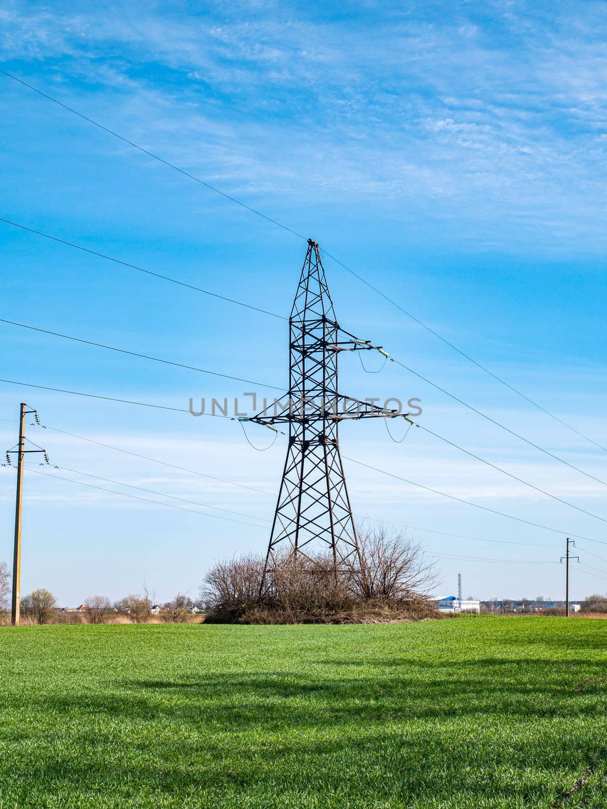 The tower of a high-voltage line of electric power transmission on a background of blue sky. Technology. Electrical equipment. Sky horizon Background image. Place for text.