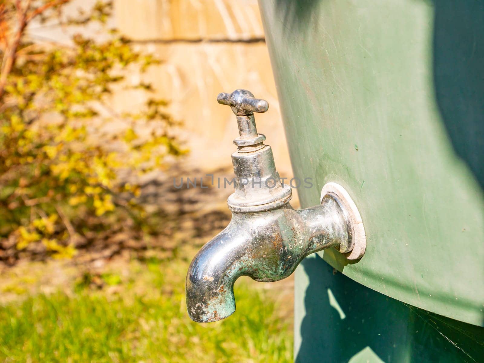 A water tap with a stainless steel valve on the water tank. Plumbing equipment. Tool. Background image. Place for text.
