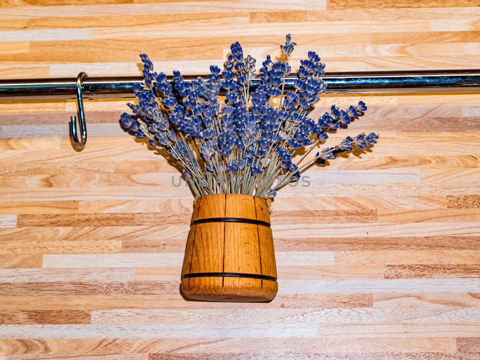 Decorative bouquet of forest violets in a wooden vase on the wall. Background image. Place for text. Decor and decoration.