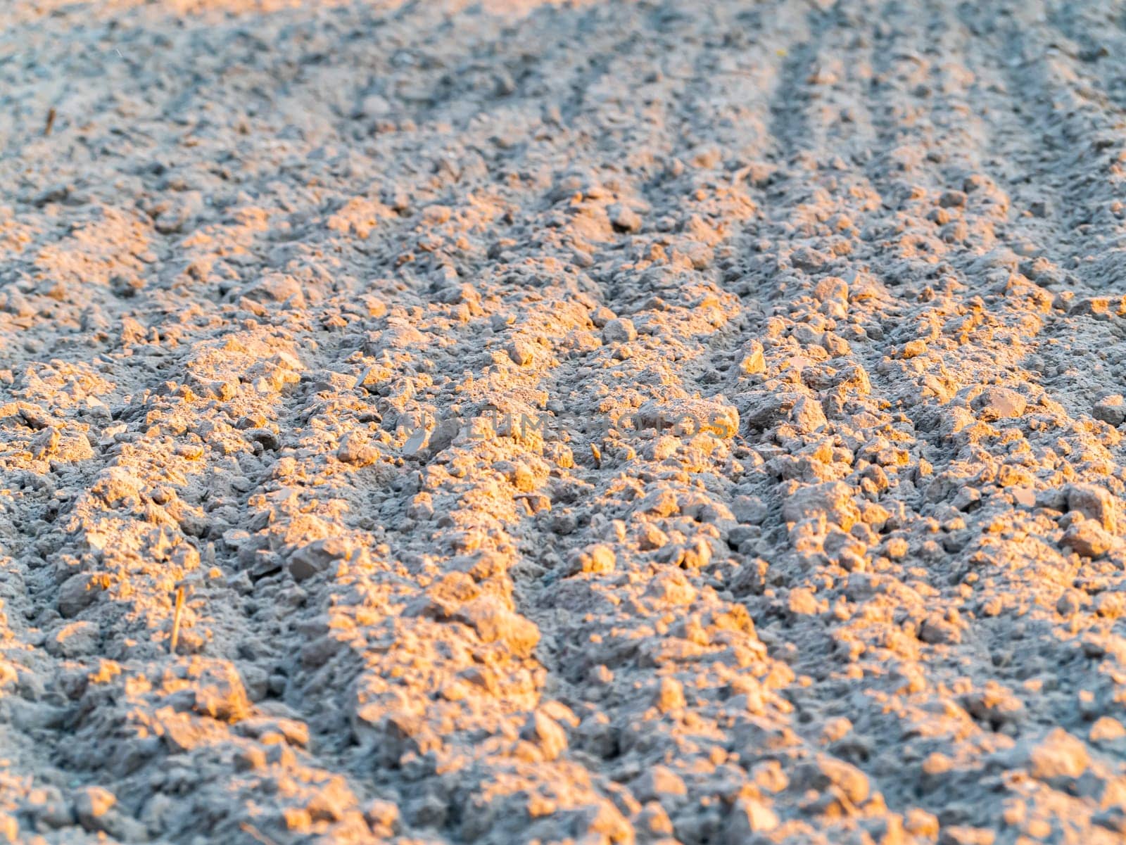 Plowed land on a farm field under the sun's rays. Agriculture. Background image. Place for text. Spring sowing.