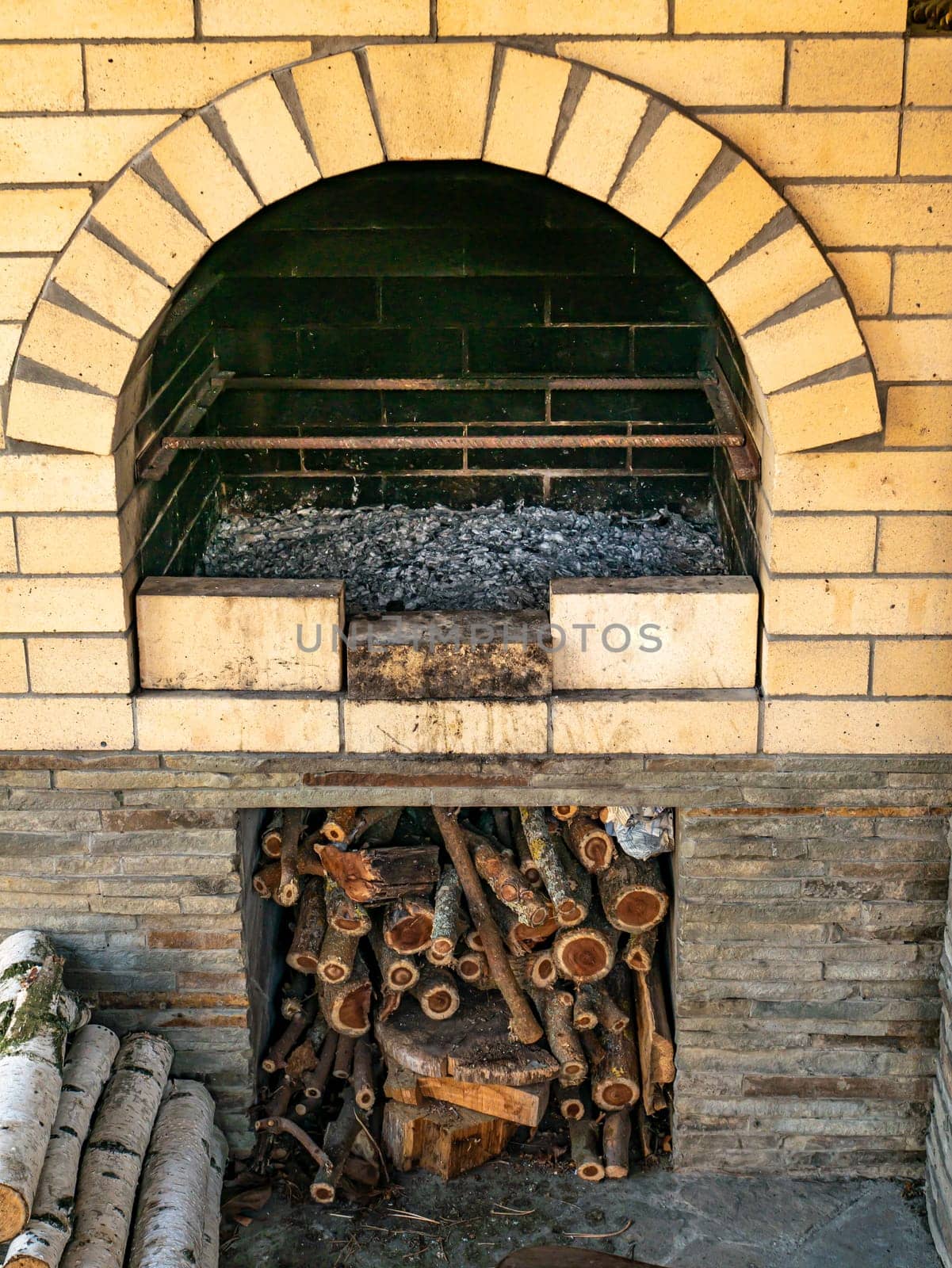 Brick wood stove with firewood on the street. Cooking. Place for text. Background image.