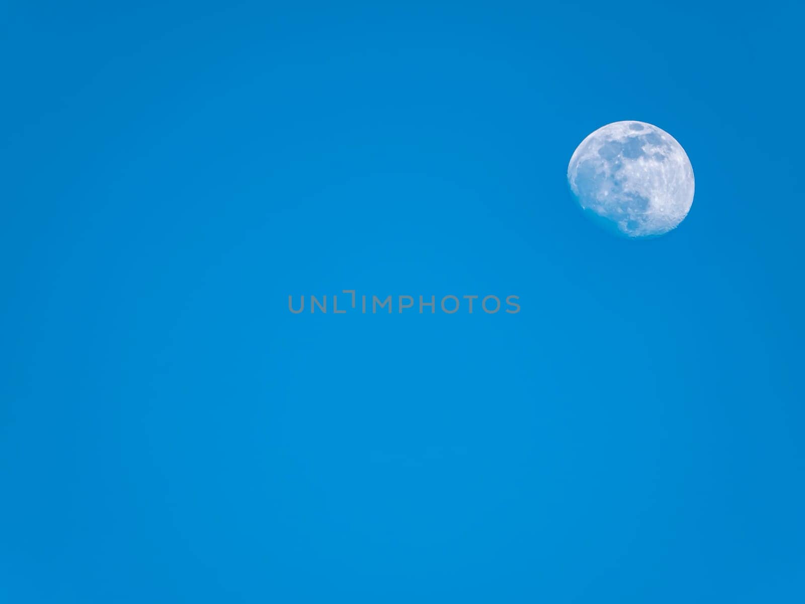 The moon against the evening blue sky. Space. Satellite of the planet earth. Place for text. Background image.