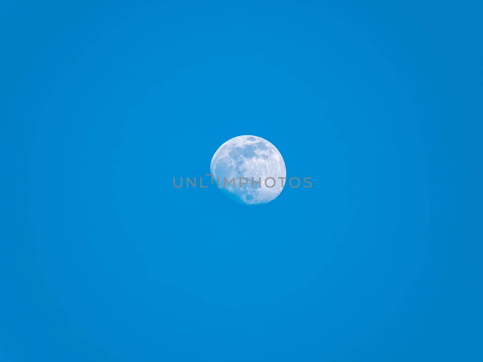 The moon against the evening blue sky. Space. Satellite of the planet earth. Place for text. Background image.