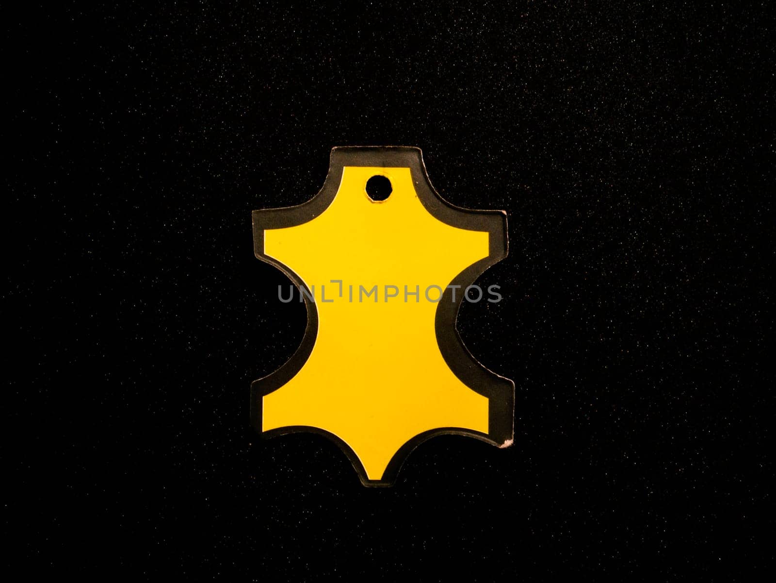 Yellow tag for clothes on a black background. Place for text. Template for text. Background image. Price tag. Tag. Poster. Advertising on the billboard. Free place. Clothing store. Shop window.