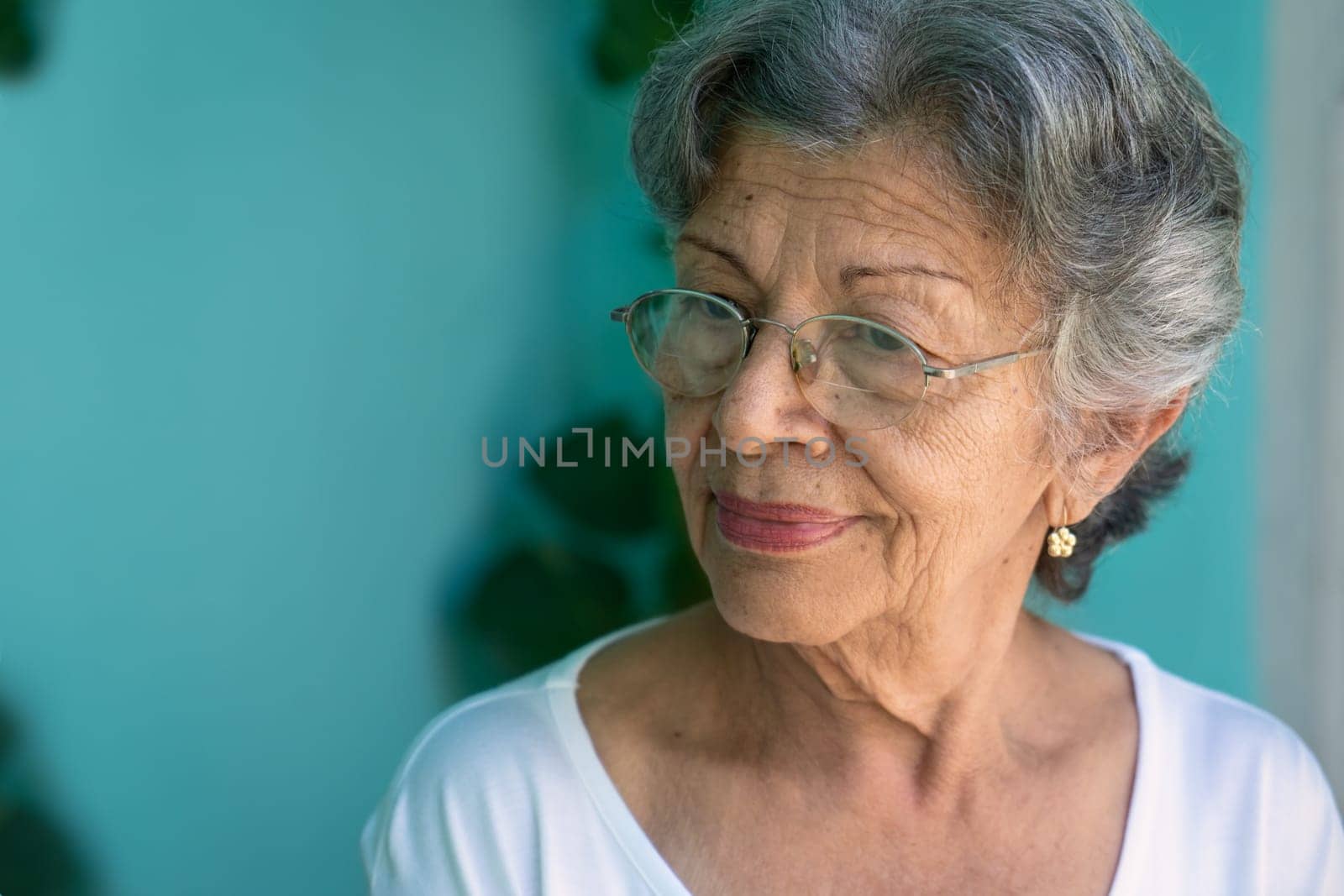 Photo of an old woman wearing glasses. Her skin is wrinkled and her hair has a lot of gray