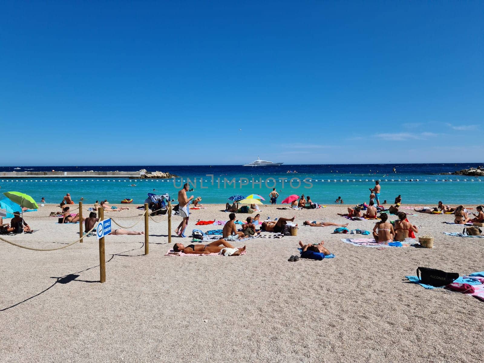 Monte-Carlo, Monaco - August 1, 2021: Crowd Of People Sunbathing On Larvotto Beach In Summer, Blue Mediterranean Sea In Monte-Carlo, Monaco On The French Riviera, Europe