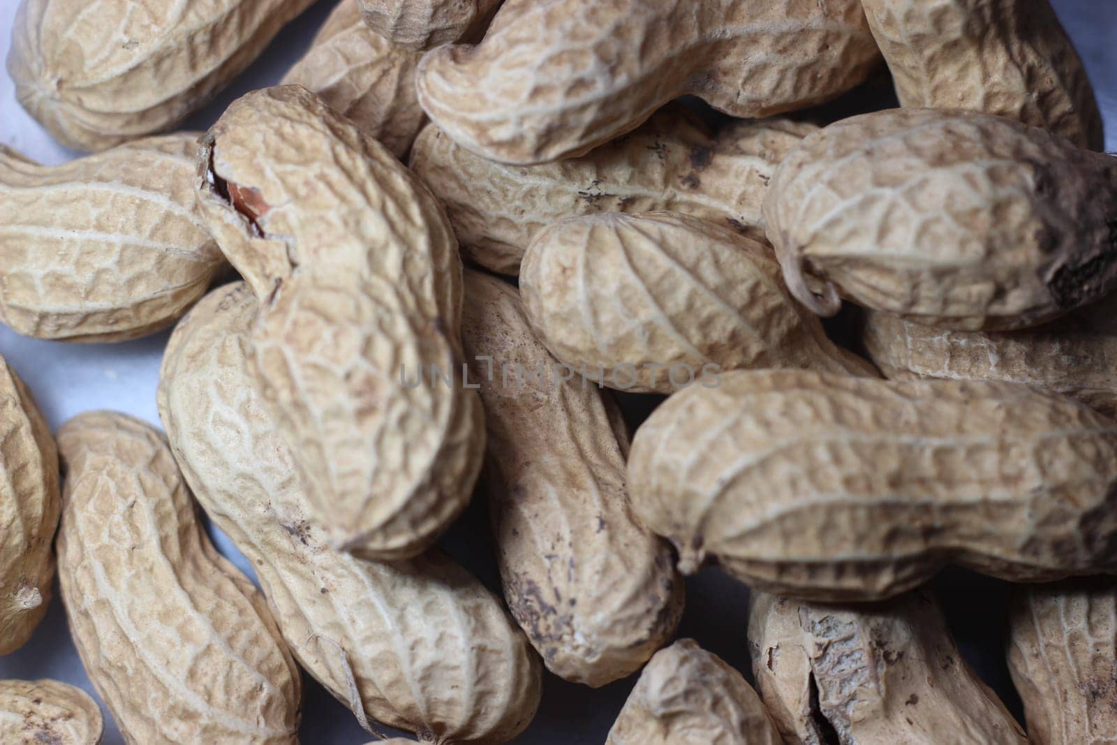 Unpeeled peanut with shells. Food background of peanuts