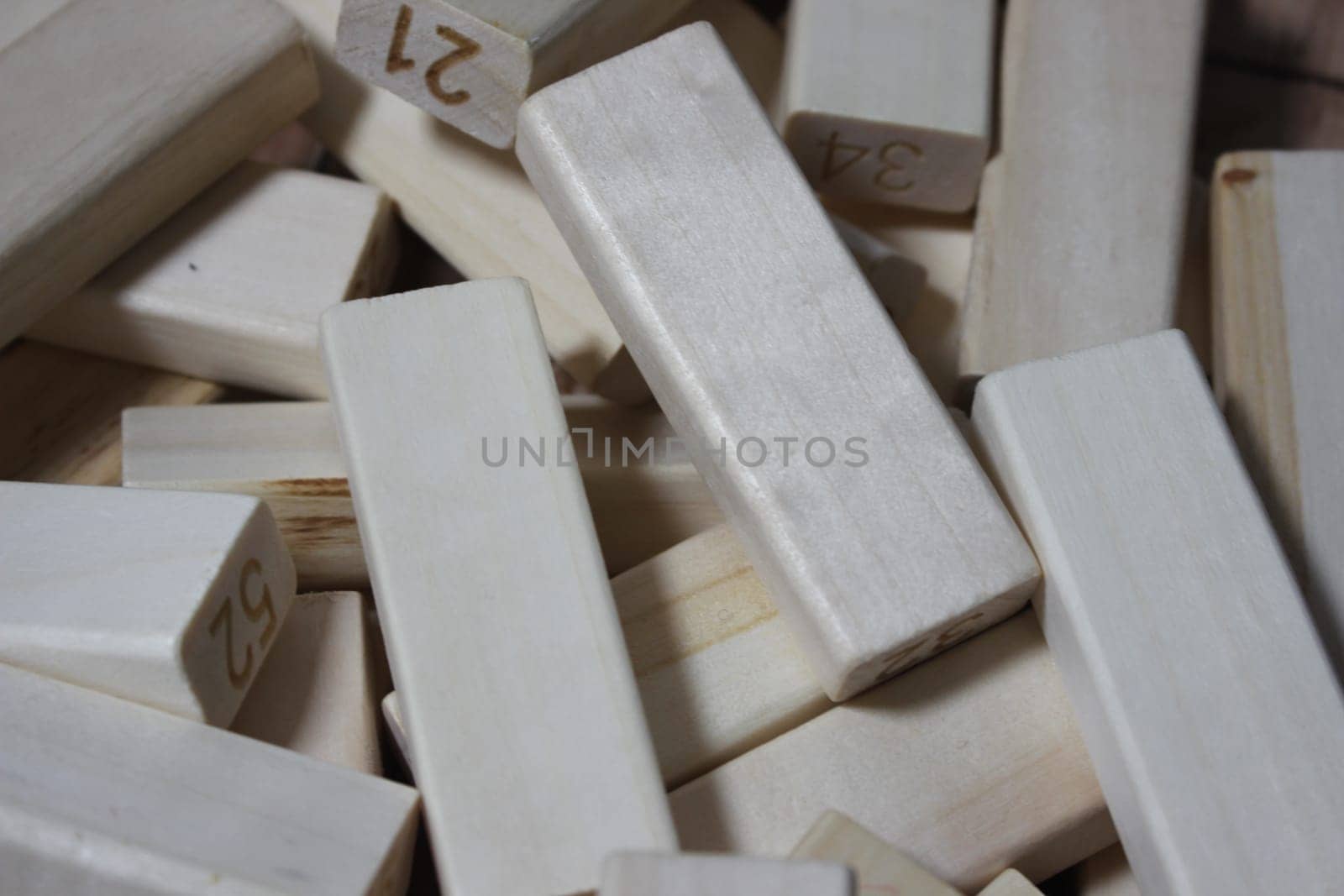 Pile of wooden blocks with engraved letters dispersed on floor. Children toy for building creative works.