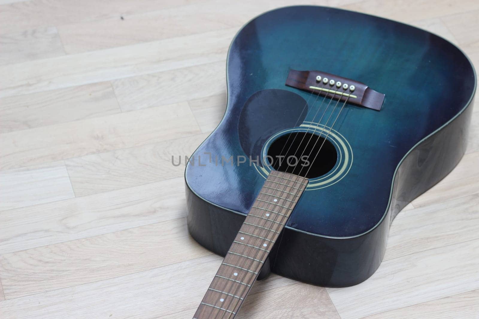 Close up of music guitar. Acoustic guitar with strings on a wooden floor
