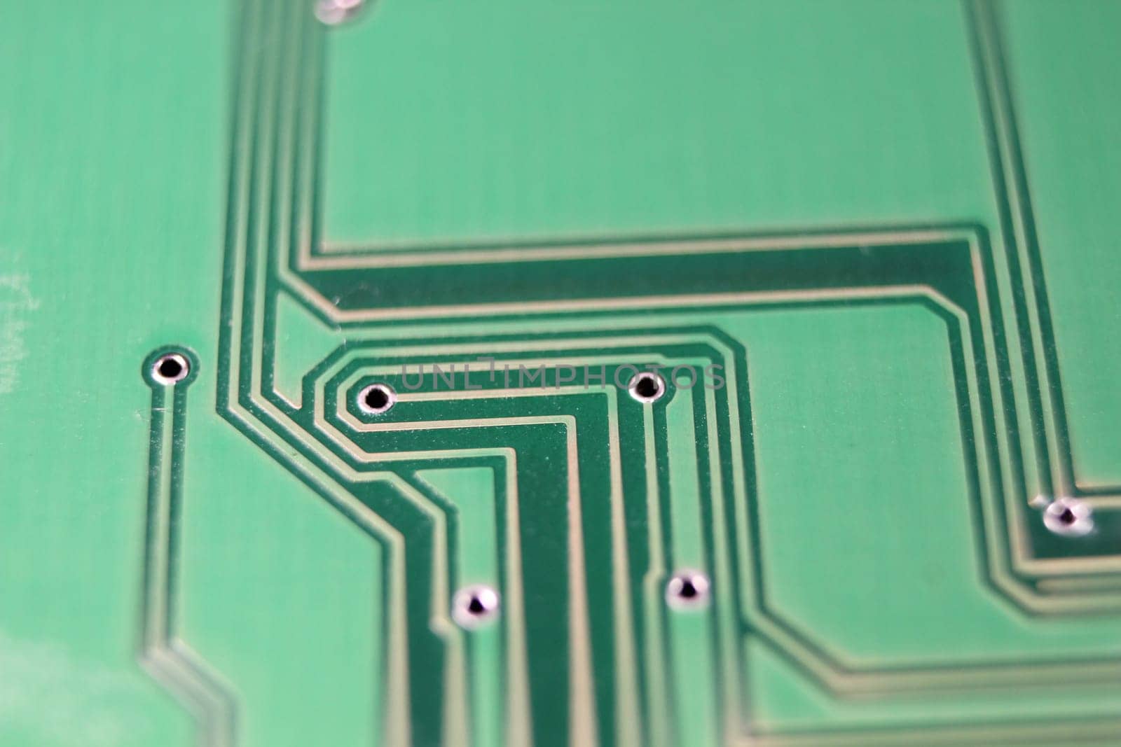 Electronic board with circuit lines and chip. Macro view of green board