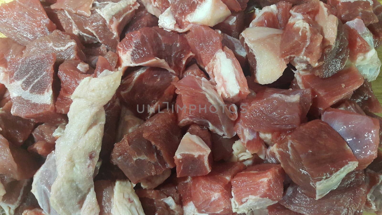 Close up view of fresh finely chopped meat cubes. Red meat small steaks with whitish meat fat.
