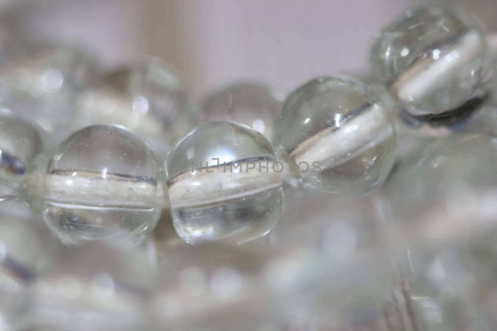 Macro photograph with selective focus of glass shiny prayer beads or rosary with copy space for text. Religion concept of ramadan or Eid for muslims.