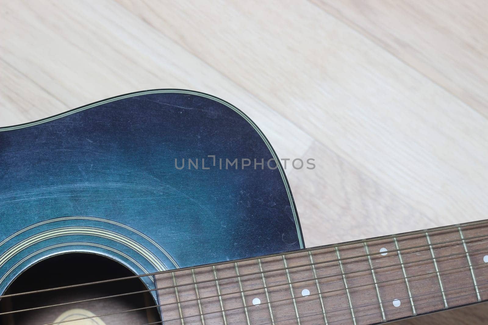 Close up of music guitar. Acoustic guitar with strings on a wooden floor