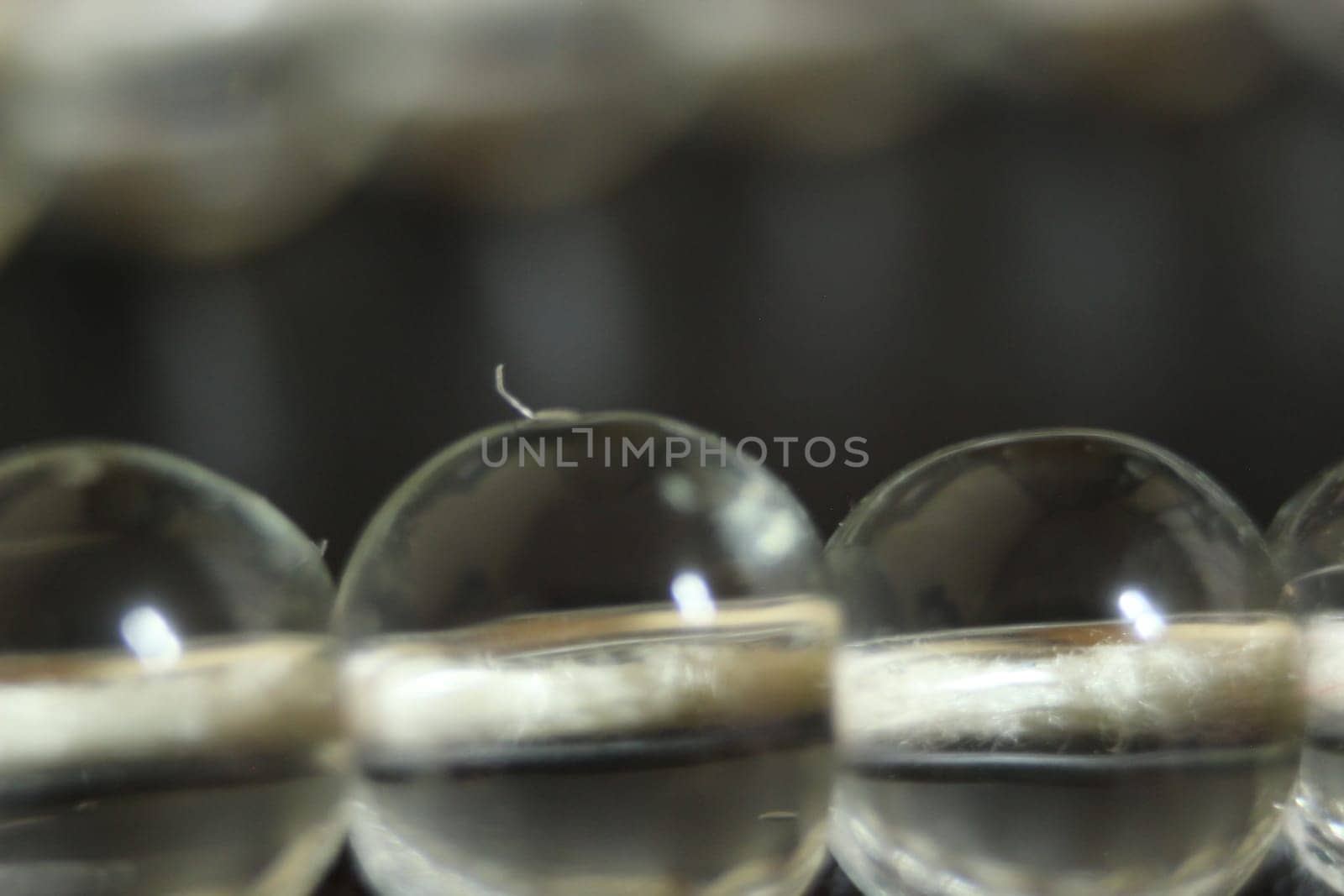 Macro photograph with selective focus of glass shiny prayer beads or rosary with copy space for text. Religion concept of ramadan or Eid for muslims.