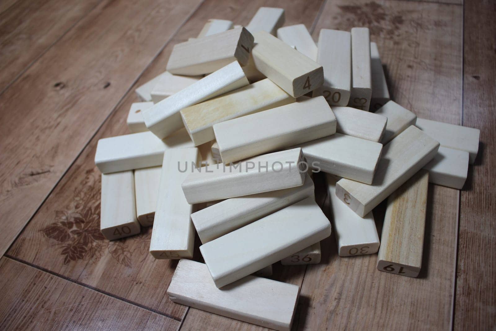 Pile of wooden blocks with engraved letters dispersed on floor. Children toy for building creative works.