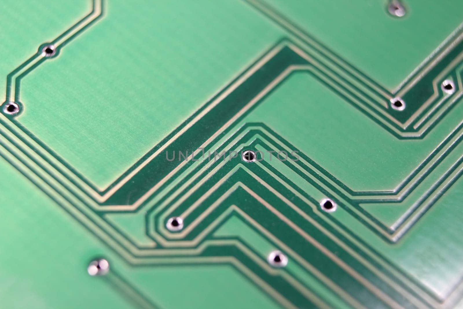 Electronic board with circuit lines and chip. Macro view of green board