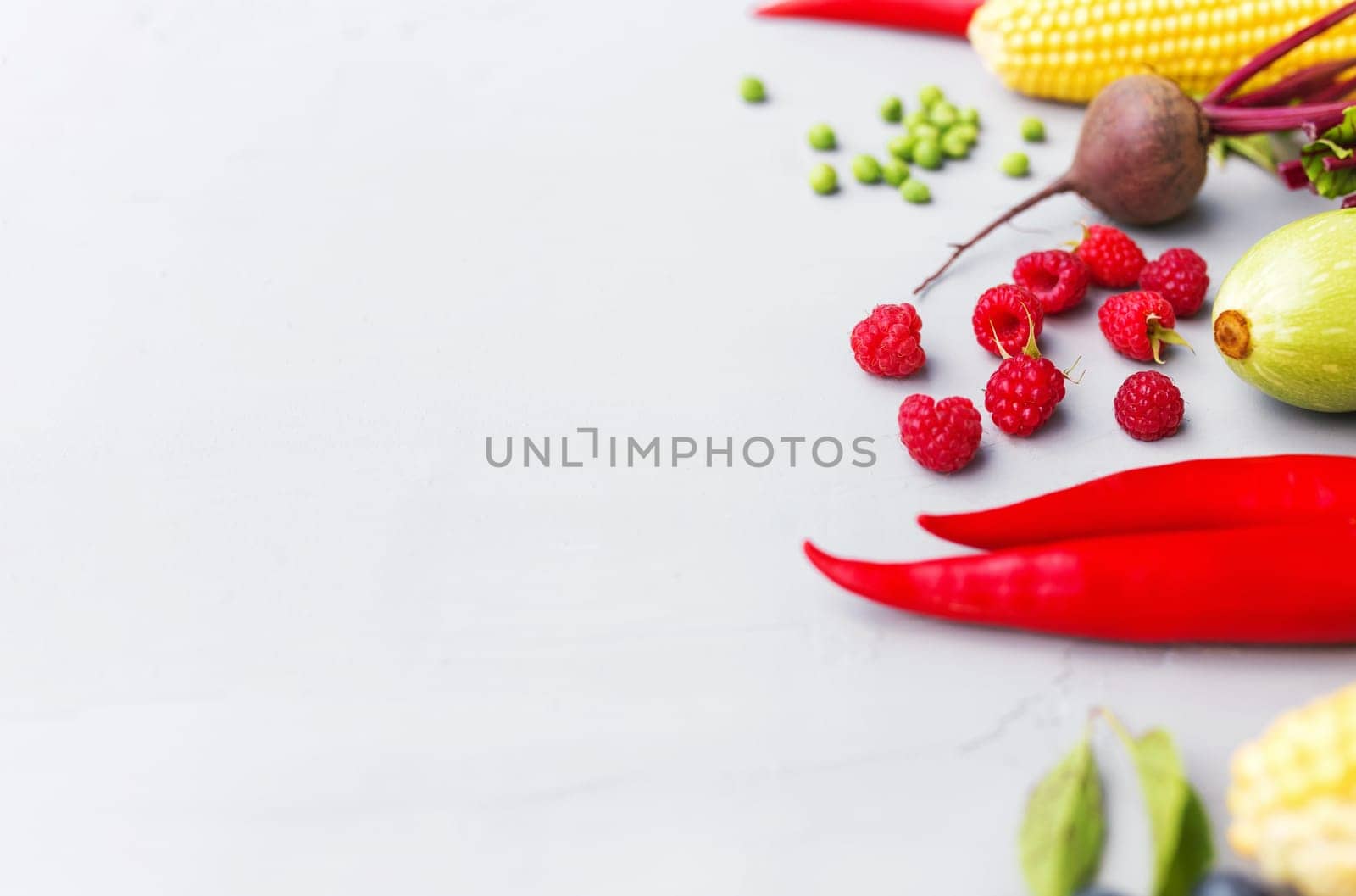Flat lay with different vegetables, fruits, berries, nuts, spices, herbs, olive oil. Copy space area for some text. Veggies on grey concrete background. Concept of organic bio food healthy eating