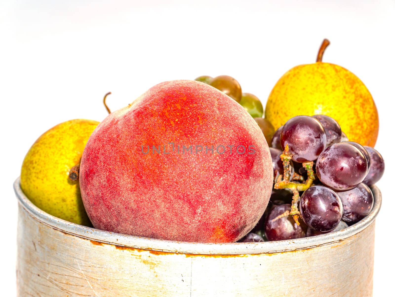Peach fruit harvest with pear and grapes on a white background. Red peach. Green pear. Blue grapes. Harvesting. Food photo. Sweet food. Vitamins. Aluminum pan. Agriculture. Fruit shop showcase.