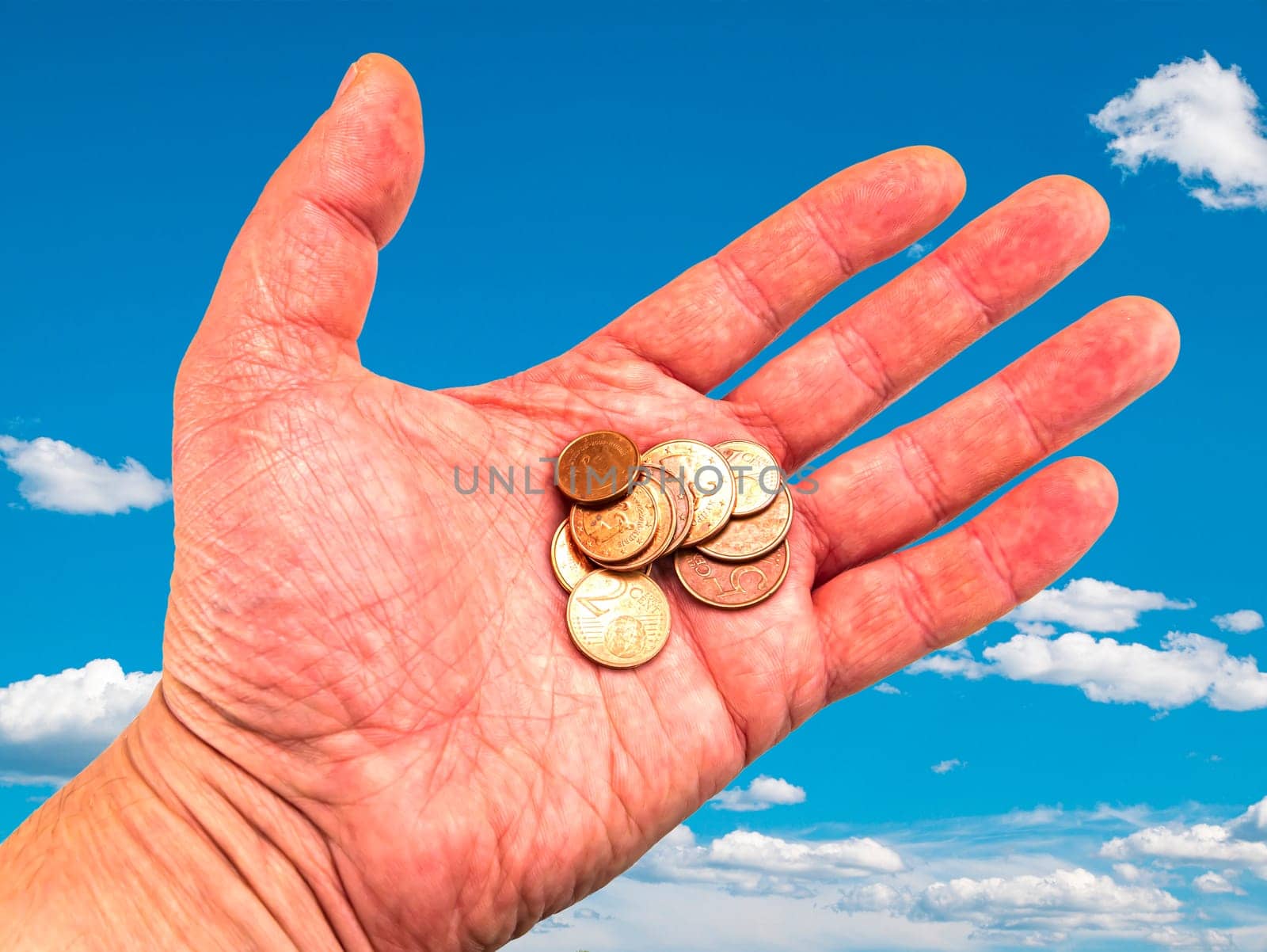 Hand with money coins on a background of blue sky. God's gift. Prayer. Request for help. Asking for money. Giver's hand. Sunbeams. Euro money. Background image. Place for text. Poster.