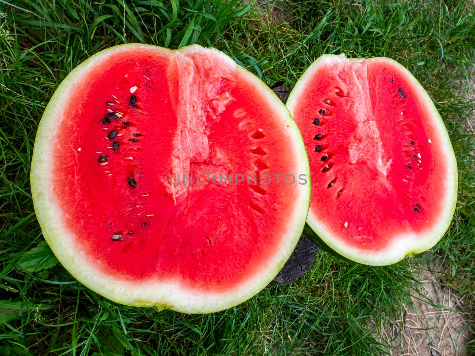 Red watermelon with seeds cut with a knife. Berry. Food photo. Place for your text. Harvest of watermelons. Background image. Poster. Advertising photo of a shop window. Summer season. Fruits.