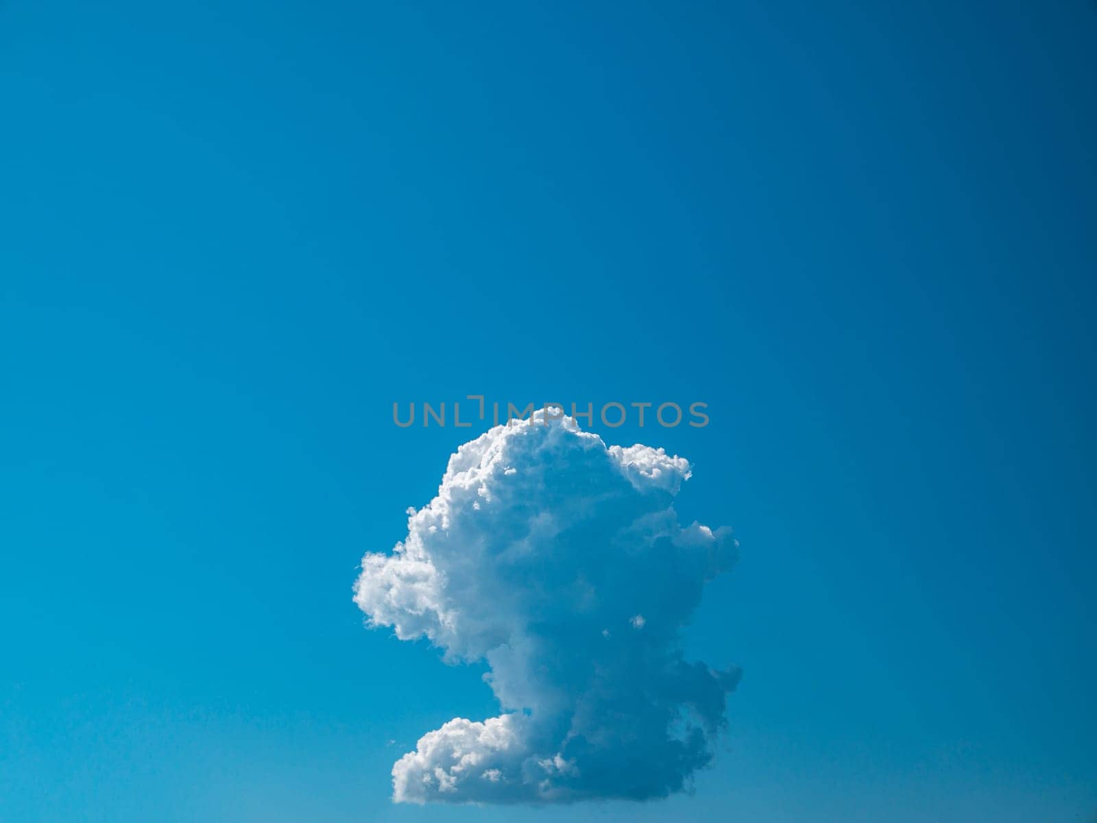 White cumulus cloud against blue sky in sunlight. Cloudy landscape. Background image. Heavenly paradise. Place for your text. Advertising photo. Poster. Template.