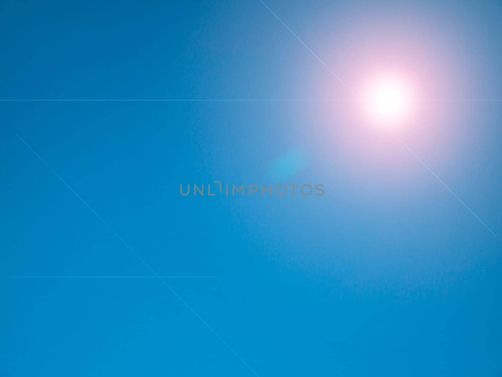 Sun rays on a background of blue sky. Natural background. Lens flare in the sun. Heavenly landscape. Space. Stratosphere. Background image. Poster. Place for text. Clear sky.