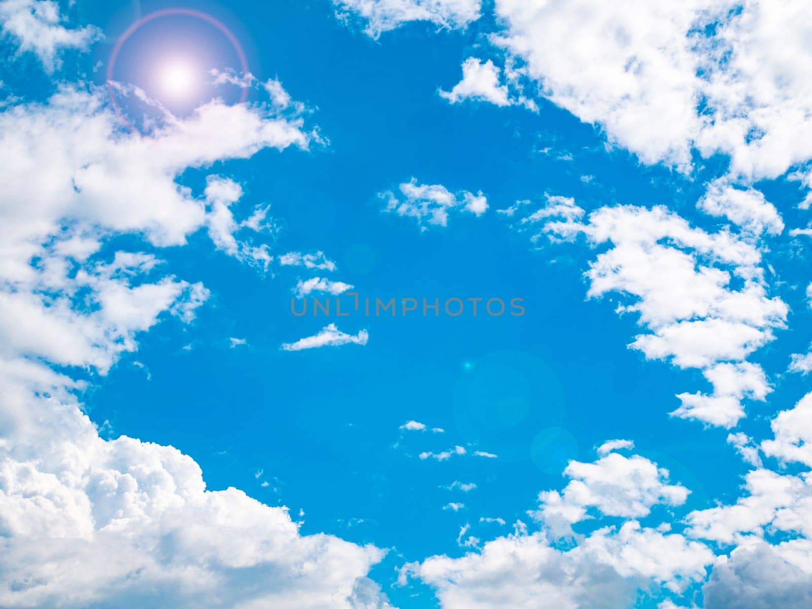 The sun on the background of the cloudy sky. Background image. Sun glare. Camera lens flare. Place for text. Poster. Template. Cloudy landscape. Weather cyclone. Windy weather. Climate change.