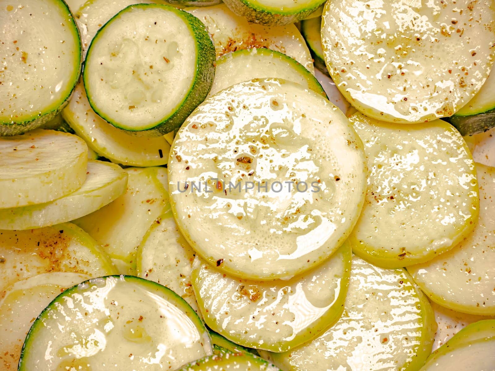 Sliced vegetable zucchini with seasoning in stirring. Food photo. Cooking food. Home kitchen. Cucumber vegetable. Vegetarian food. Showcase advertising photo. Human face. Green salad.
