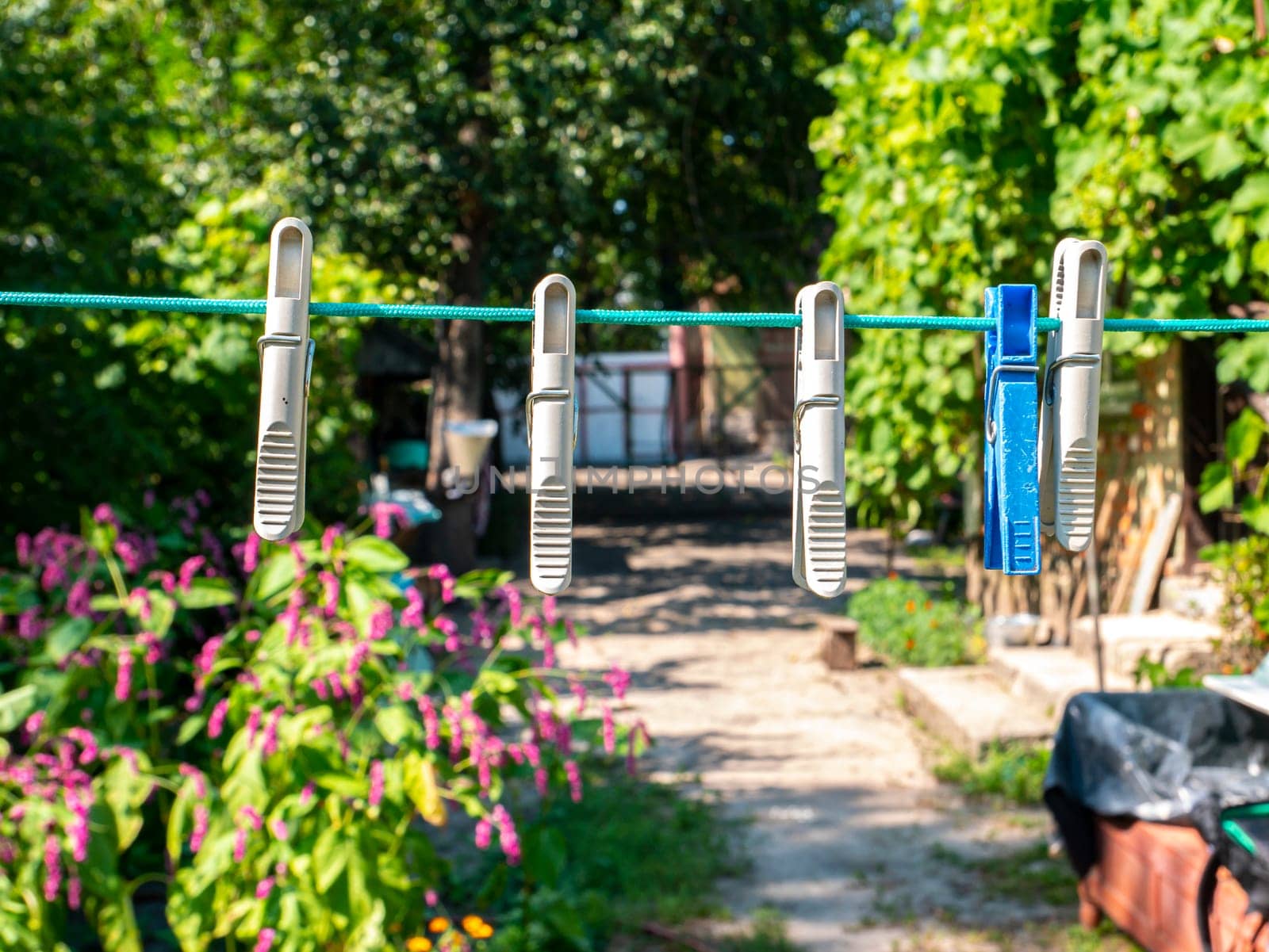 Clothespins hang on a clothesline to dry the clothes. Household. Gen. Background image. On the street. Place for text. Template. Poster.