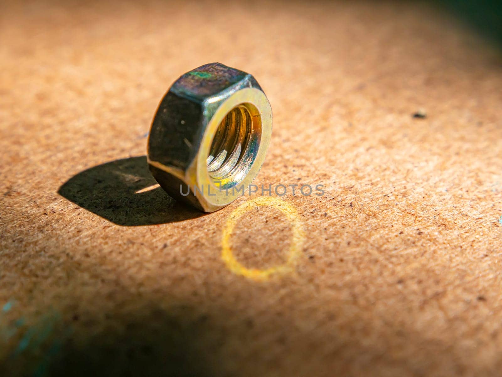 Iron nut on a wooden table macro photo. Iron nut. Locksmith material. Wooden background. Macro photography. Background image. Place for text.