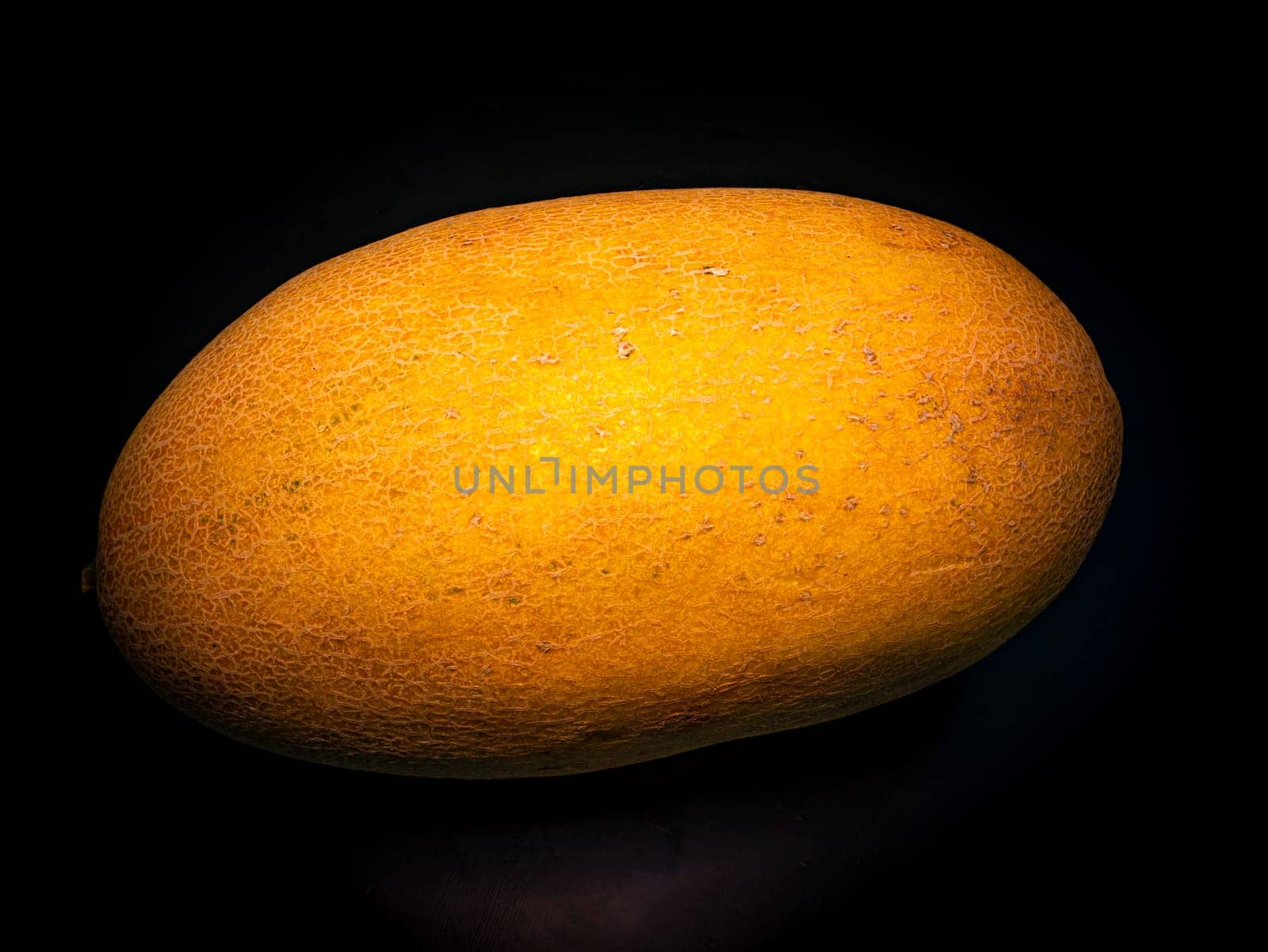 Yellow ripe melon on a black background. Food photo. Melon culture. Agriculture. Place for your text. Black background. Background image. Shchablon. Poster. Vegetarian food.