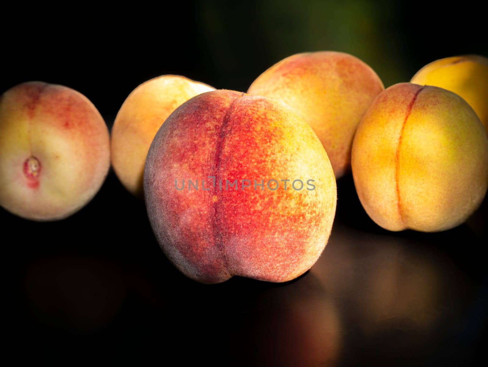 Ripe peach fruit on a black background. Food photo. Harvesting. Peach juice. Agriculture. Advertising photo of a shop window of a fruit shop. Place for your text. Background image. Template. Poster.