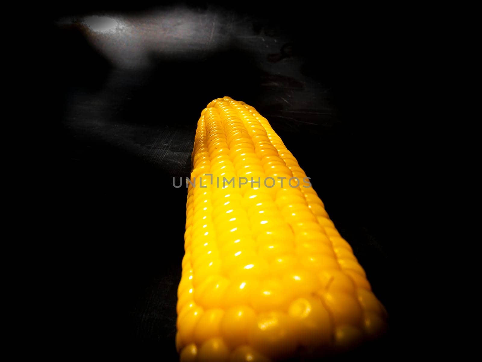 Yellow swing of corn on a black background. Boiled corn. Harvest. Agriculture. Food photo. Black background. Place for your text. Background image. Poster. Vegetarian food.