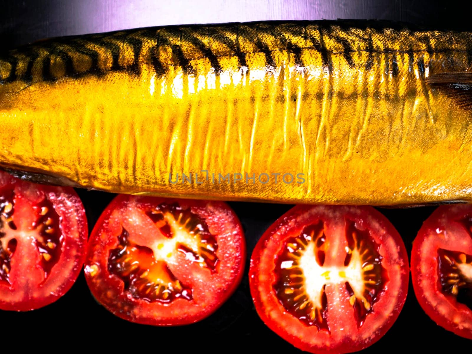 Smoked fish mackerel and tomatoes on a black background. Salted mackerel fish. Canned food. Food photo. Recipe. Menu of dishes. Vegetarian food. Home kitchen. Fishing. Background image.