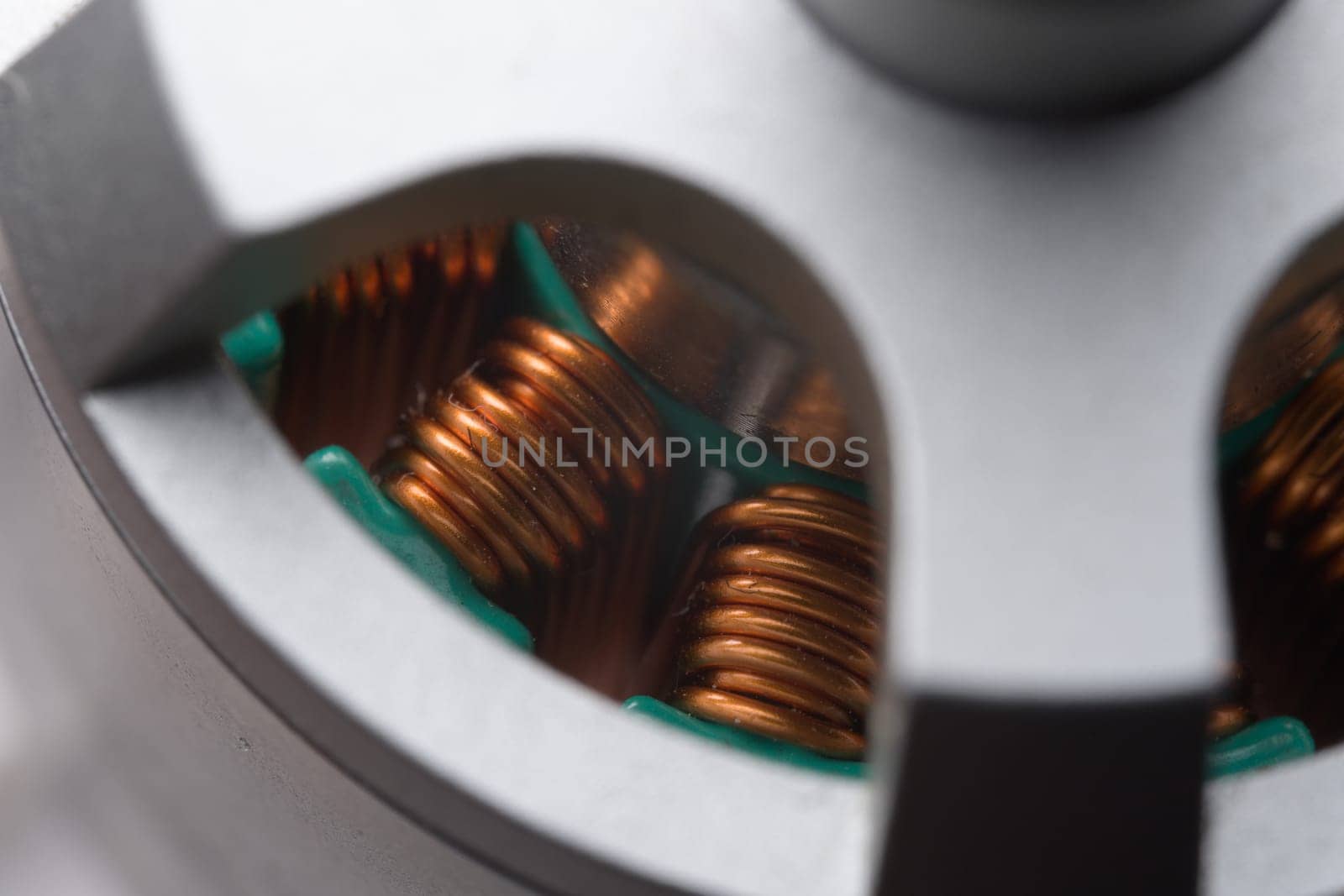 Closely looking down into tall copper coils or stators within a brushless electric drone motor. Three color metallic theme, very detailed close up.
