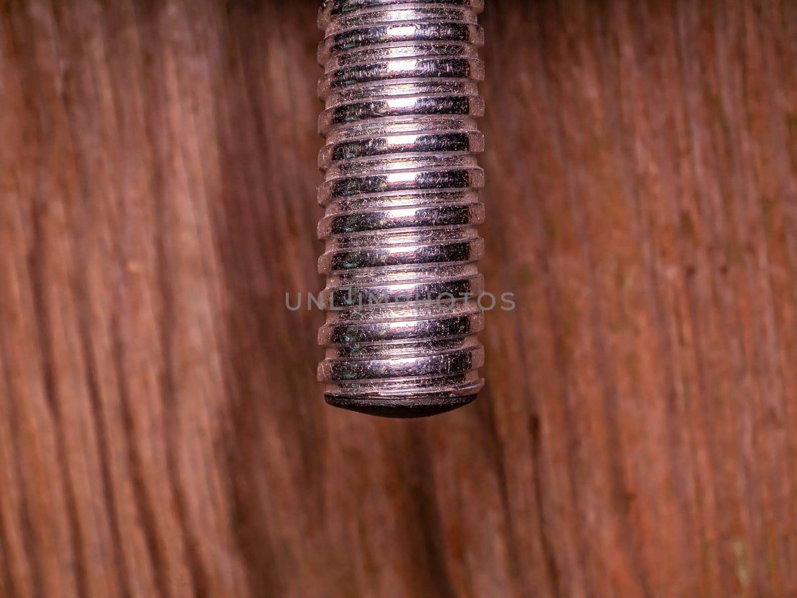 Iron bolt with thread for tightening the nut. Threaded connection of parts with a bolt and a nut. Parts fastening technology. Locksmith accessories. Background image. Place for your text.
