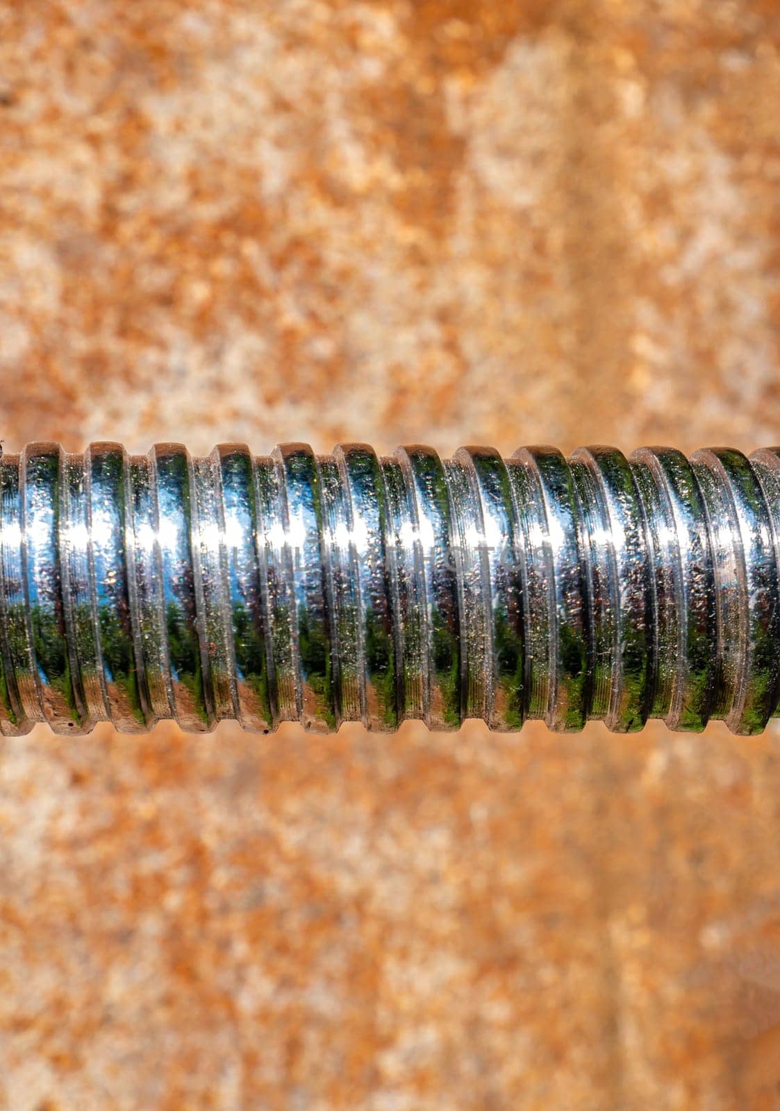 Iron bolt with thread for tightening the nut. Threaded connection of parts with a bolt and a nut. Parts fastening technology. Locksmith accessories. Background image. Place for your text.