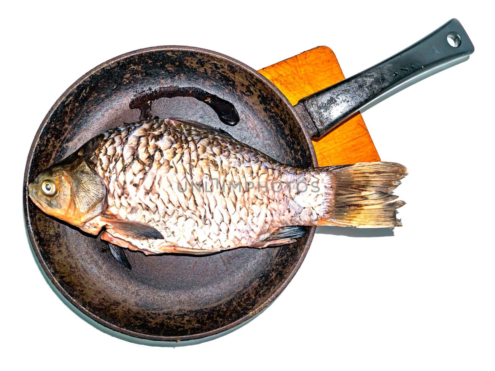 Fish crucian carp in a pan on a cutting board. Freshwater fish crucian carp. Menu of dishes. Fishing catch. Cooking food. Home kitchen. Place for your text. Background image. White background.
