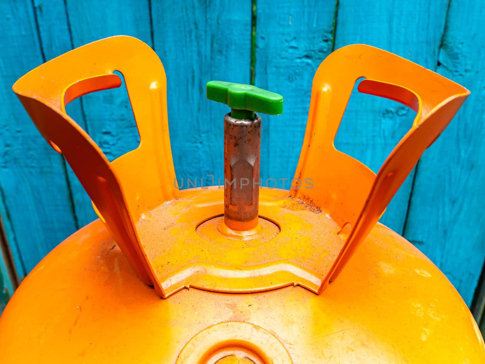 Refrigerant cylinder for the repair of refrigeration equipment. Orange bottle with freon. Refrigerator and air conditioner repair tool. Technological equipment. Service of climatic equipment.