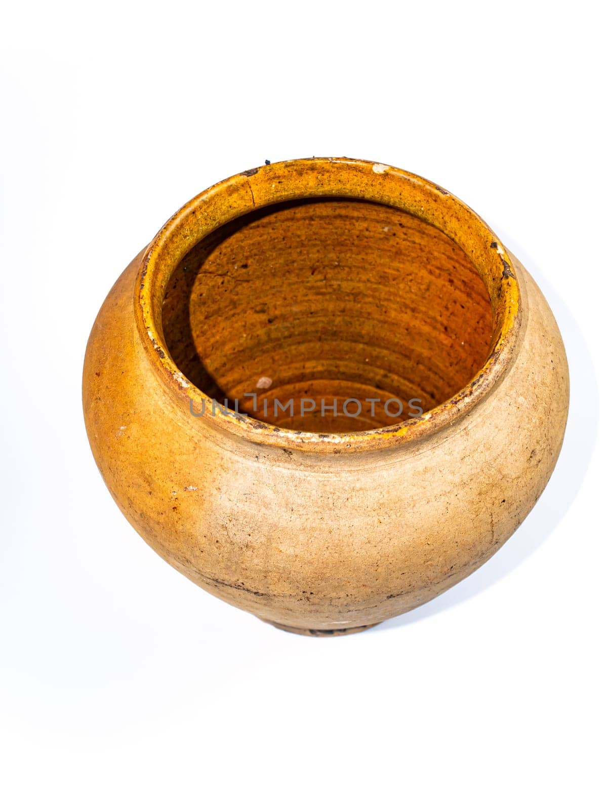 Ceramic clay jug on a white background. Old kitchen utensils. Handmade clay jug. White background. Background image. Place for text.