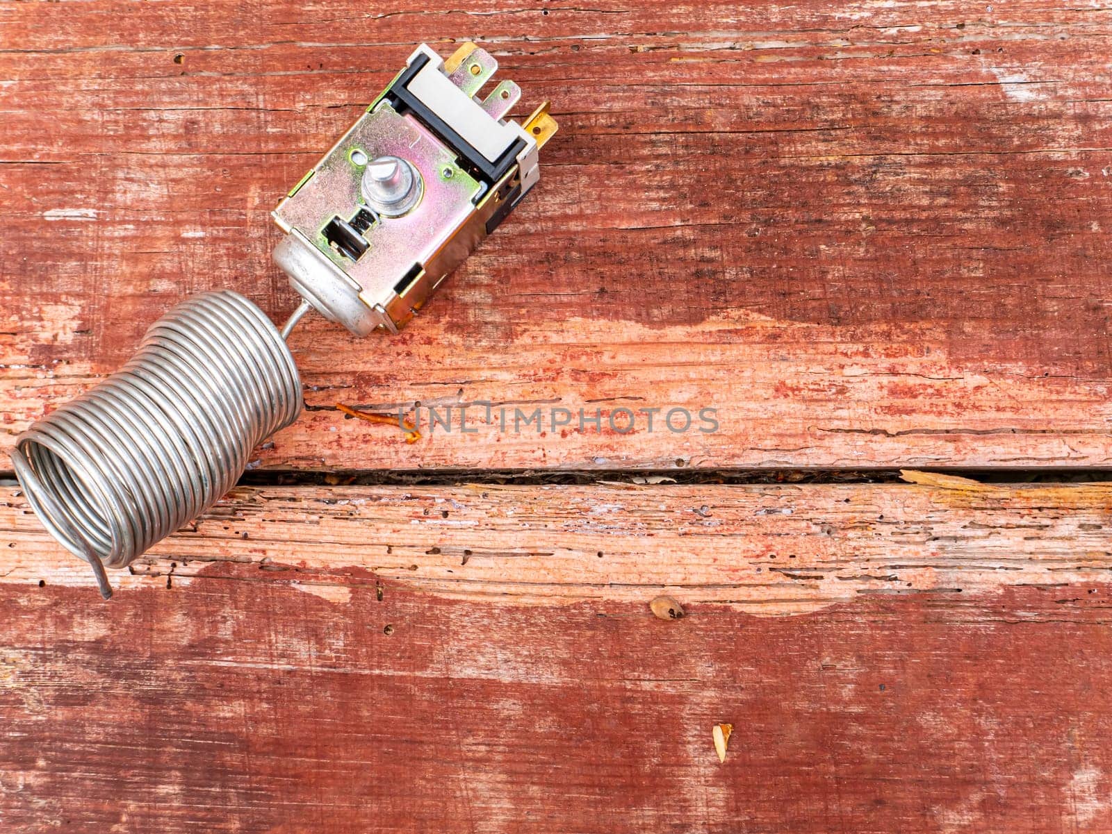 Thermostat is a spare part for refrigerator repair. Refrigeration equipment thermostat. Temperature relay for climatic technology. Refrigerator repair service. Replacement part. Detail.