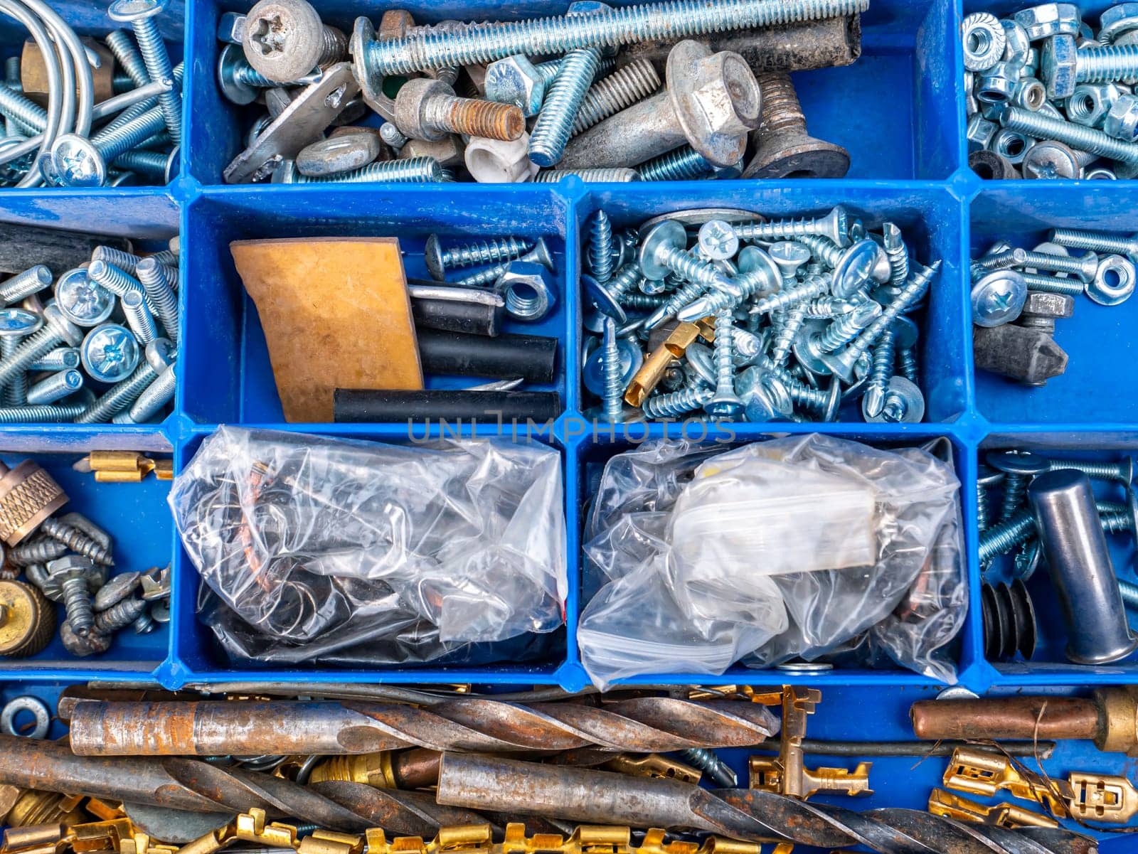 Working tool plastic case with bolts and nuts. Threaded connection of metal parts. Parts fastening technology. Drill bits. Locksmith accessories. Background image. Place for your text.