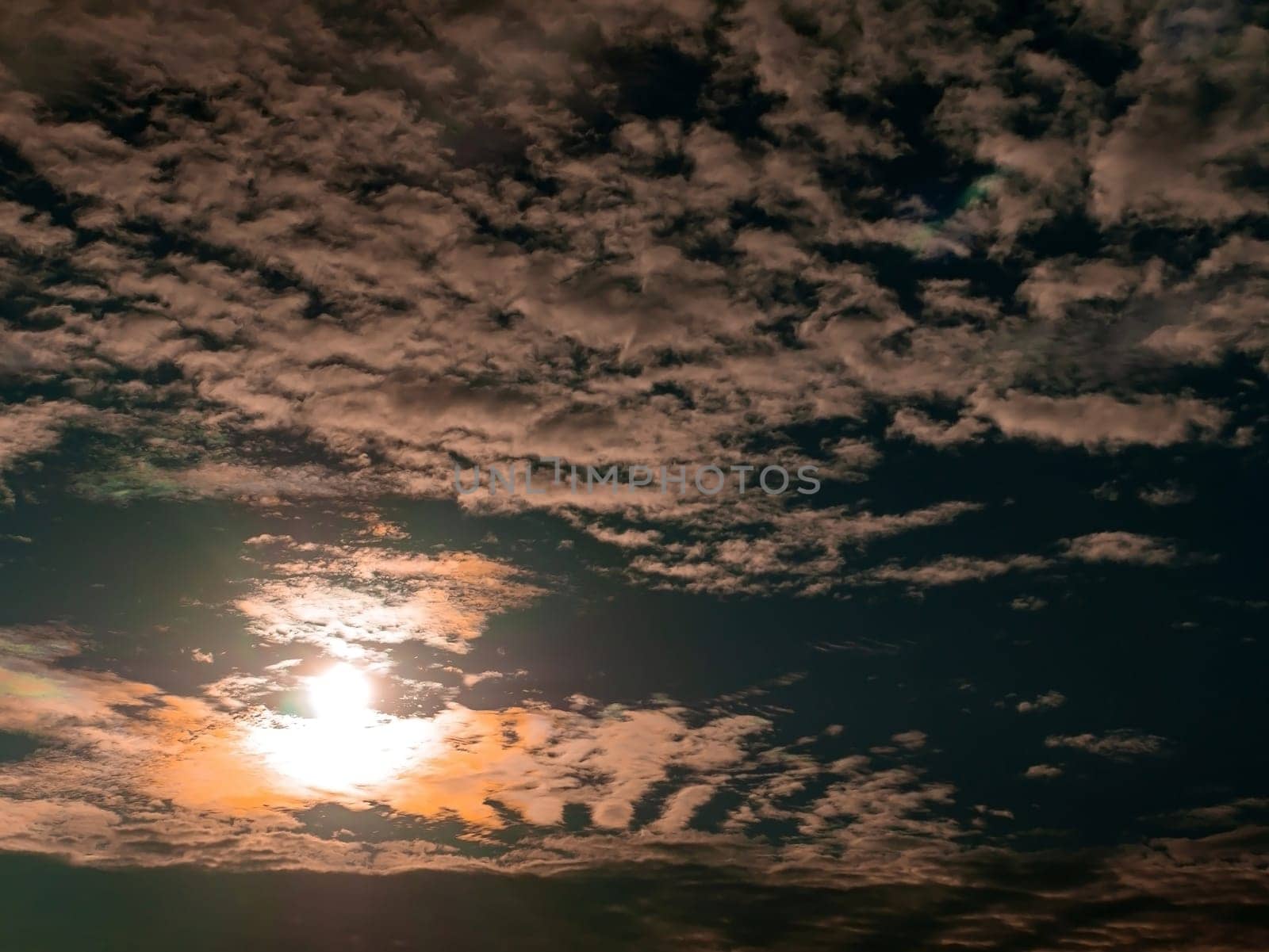 Evening orange sunny sunset behind white clouds on blue sky. Morning sunrise. White clouds. Blue set. Weather. Synoptic weather forecast. Stratosphere. Space. Background image. Place for text.