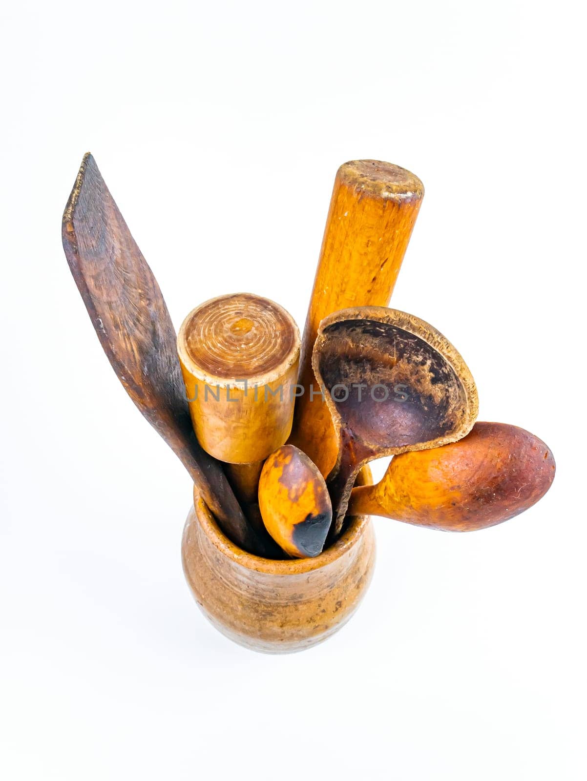 Ceramic clay jug with wooden kitchen utensils. Old kitchen utensils. Handmade clay jug. Wooden kitchen spoons. White background. Background image. Place for text.